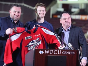 Seen with head coach Marc Savard, at left, and general manager Bill Bowler, at right, Shane Wright is comfortable with the attention he'll draw after joining the Windsor Spitfires.