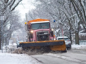 A snow plow clears and salts Lillian Avenue in Remington Park after a snow storm, on Wednesday, Jan. 26, 2023.