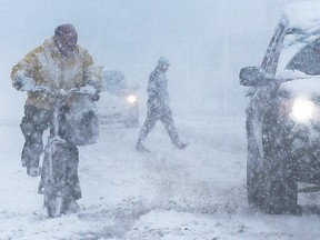 A cyclist struggles through the snow on University Avenue West in Windsor on Wednesday, January, 25, 2023 during a heavy snowfall.