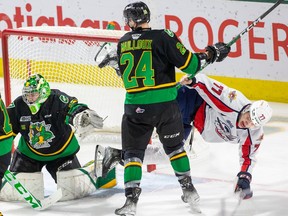 London Knights' defenceman Logan Mailloux helps out goalie Brett Brochu by upending Windsor Spitfires' forward James Jodoin during Sunday's game at Budweiser Gardens.
their game at Budweiser Gardens.