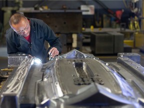 Sappo Khamphasath works on a spotting press at Cavalier Tools, on Friday, Jan. 20, 2023.