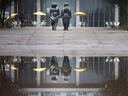 Large puddles from snow melt and rain cover Charles Clark Square as they reflect a promenade sculpture in front of city hall on Jan.  1, 2023.