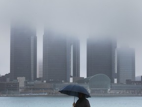 A man walks along a rainy and foggy downtown Windsor riverfront on Tuesday, January 3, 2023.