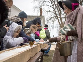 An interpreter ladles out syrup to make maple taffy at the Tasters' Weekend.   -  Photo Supplied