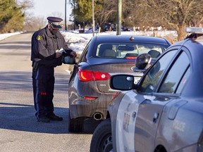 An OPP officer in Brant County conducts a traffic stop with a breath screening device in this December 2020 file photo.
