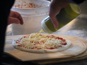 Cucina 360 owner Remo Tortola makes a pizza pie at the official opening of the Chatham Street West restaurant in downtown Windsor on Wednesday, February 8, 2023.