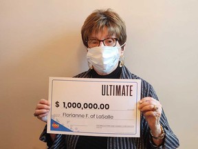 Florianne Fournier of LaSalle holds her $1-million prize cheque from playing Instant Ultimate.