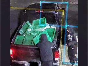 A surveillance camera image showing suspects and a pickup truck involved in a break-and-enter theft at a commercial property in LaSalle.