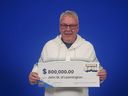 John Watkins of Leamington holds his prize cheque for $800,000 - which he won playing the OLG game The Bigger Spin.