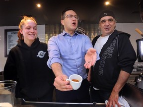Pierre Poilievre, leader of the Conservative Party of Canada, centre, displays an espresso he made at the Gennaro's Cafe on Erie Street in Windsor on Friday, February 10, 2023 as Kayla Mummery and Dennis Ciotti look on.