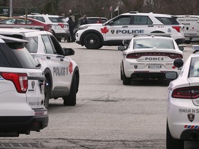 Police vehicles gather in the area of Ouellette Avenue and Riverside Drive in downtown Windsor on Feb. 28, 2023.