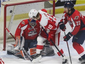 Windsor Spitfires goalie Ian Michelone makes a save as Sault Ste. Marie Greyhounds' forward Christopher Brown looks for a rebound against Windsor defenceman Nicholas De Angelis during Thursday's game.