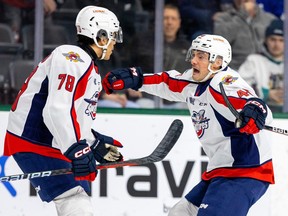 The Windsor Spitfires' Rodwin Dionicio, left,  moves in to congratulate Alex Christopoulos after a goal as his hat-trick performance on Friday helped the club to a 6-3 win in London against the Knights that clinched top spot in the Western Conference.