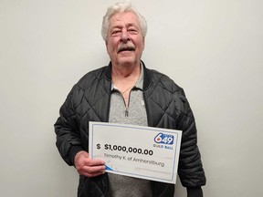 Timothy Kelly of Amherstburg holds his $1-million prize cheque from a Lotto 6/49 Gold Ball Draw.