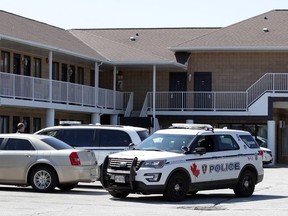 Windsor police gather at the rear of the Motel 6 on Huron Church Road on April 2, 2020, following an overnight homicide nearby on Northway Avenue.