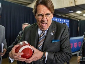 Quebecor CEO Pierre-Karl Péledeau rushes a photographer like a running back after a news conference where he was introduced as the new owner of the Montreal Alouettes in Montreal Friday March 10, 2023.