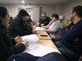 Rebuilding lives. Patty Castro, second from right, a settlement worker with Matthew House Refugee Welcome Centre in Windsor helps refugee claimants with paperwork on Tuesday, March 14, 2023.