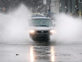 Flat topography, surrounded by water and increasingly severe weather add up to high local home insurance rates. Here, a motorist plows through a flooded section of Howard Avenue in Windsor on Jan. 11, 2020.