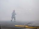 A firefighter is shrouded in smoke in the 300 block of Giles Boulevard East in Windsor on March 29, 2023.