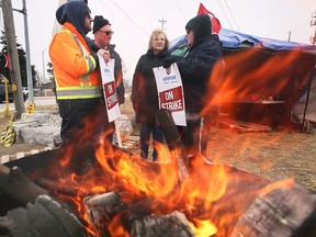 Windsor Salt striking employees Oliver Jones, left, Bill Wark and Kim Cornies, extreme right, speak with Unifor National President Lana Payne who visited them on the picket line on Friday, March 3, 2023.