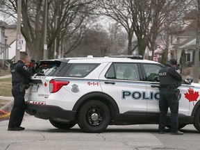 Windsor police officers take cover and point firearms at a home in the 1000 block of Lincoln Road on March 27, 2023.