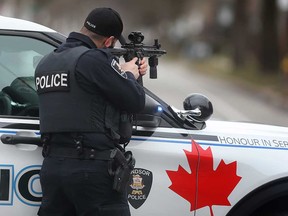 A Windsor police officer keeps watch and trains a rifle at a home in the 1000 block of Lincoln Road on March 27, 2023.