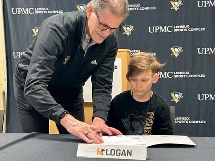  Penguins general manager Ron Hextall signs a one-day contract March 8, 2023, with Windsor’s Logan Ferriss, 13. Jackie Ferriss photo courtesy of Make-A-Wish Foundation.