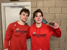 Windsor Spitfires' captain Matthew Maggio, at right,  holds the puck that gave him his 50th goal of the season on Thursday with teammate Jacob Maillet, left, who assisted on the goal.