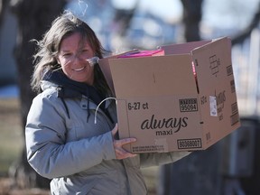 Alison Pound, a volunteer with the Tampon Tuesday event carries a box of donations at the Harbour House in Windsor on Tuesday, March 7, 2023. The event was sponsored by the United Way.