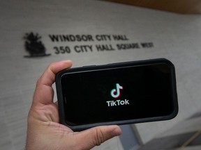 A photo illustration of the TiktTok app in front of City Hall is pictured Friday, March 10, 2023. City Hall is banning TikTok from city-owned devices.