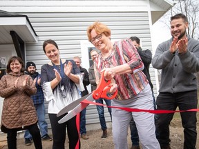 'Everything you’d expect in a house.' Cheri Robbins cuts the ribbon to her new tiny home, the first built in the Town of Essex, on Friday, March 24, 2023, as Mayor Sherry Bondy and others look on.