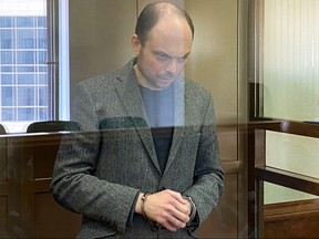 Russian opposition figure Vladimir Kara-Murza, who is accused of treason and spreading "false" information about the Russian army, stands inside a defendants' cage during his sentencing at the Moscow City Court in Moscow on April 17, 2023.