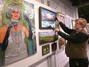 Mariano Klimowicz, curator of the Association of Representational Artists' 42nd Annual Art Show, puts the final touches on the display at the Sho Art Studios in Windsor on Friday, April 28, 2023.