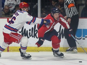 Windsor Spitfires' captain Matthew Maggio, right, tries to get around Kitchener Rangers' forward Carson Rehkopf, left, during Saturday's game at the WFCU Centre.