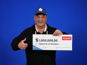 Robert Dikan of Windsor holds his $1-million prize cheque from playing the Instant Game Jackpot Multiplier, April 2023.