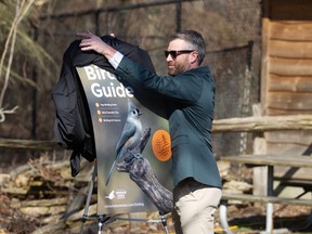 Jason Toner, director of marketing and communications with Tourism Windsor Essex Pelee Island, unveils the official city bird for Windsor, the tufted titmouse, at the Ojibway Prairie Complex on Wednesday.