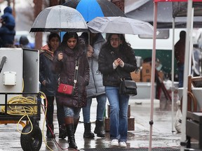 Heavy wind and rain cut the Windsor's Farmer's Market opening day short on Saturday, April 1, 2023. People walk down Pelissier Street in the rain.