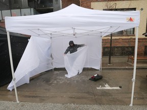 Heavy wind and rain cut the Windsor’s Farmer’s Market opening day short on Saturday, April 1, 2023. Vendor Drew Myers packs up his tent due to the rain.