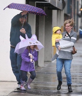 Heavy wind and rain cut the Windsor’s Farmer’s Market opening day short on Saturday, April 1, 2023. A family walks down Pelissier Street in the rain.