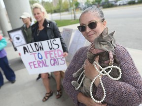 Candace Petre and cat Meatball are shown Monday, May 8, 2023, outside city hall at a protest against Windsor's recently enacted wildlife feeding bylaw on Monday, May 8, 2023.
