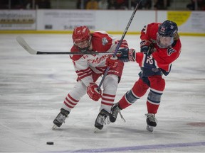 The Leamington Flyers' Hayden Reid, left, and the Stratford Warriors' Jonas Schmidt battle for the puck during Thursday's game at the Nature Fresh Centre.