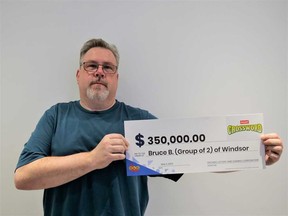 Bruce Brydges of Windsor holds his $350,000 prize cheque from playing the Instant Game Crossword Extreme. Photographed May 2023.