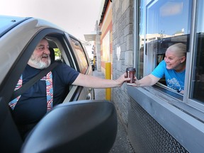 Ben Harringan gets his McHappy Day coffee from Jennifer Jovanovski, director of client services at the John McGivney Children's Centre, at the downtown Windsor McDonald's location on Wednesday, May 10, 2023.