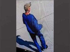 A surveillance camera image of the adult male suspect in the robbery of an elderly man at a bus stop on Walker Road on May 18, 2023.