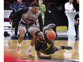 Windsor Express guard Latin Davis, left, and London Lightning forward Cameron Lard get tangled up during action in the NBL of Canada final.