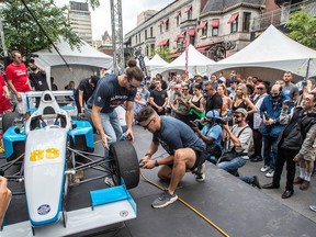 Alouettes players Marc-Antoine Dequoy and Louis-Philippe Bourassa, kneeling, took part in an F1 Pit Stop competition on Crescent St. Thursday as part of the festivities for this weekend's Canadian Grand Prix.