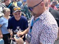 Chatham resident Jeff Parker was thrilled Hall of Famer and forner Montreal Expo Larry Walker signed two baseball cards for him at Saturday's unveiling of the Fergie Jenkins sculpture. (Ellwood Shreve/Chatham Daily News)