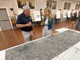 Chatham-Kent-Leamington MP Dave Epp speaks with Ani Bekmezian, a community relations consultant with Hydro One, during a community open house Wednesday in Chatham to discuss the preferred route for Hydro One's planned new St. Clair Transmission Line, expected to provide 400 megawatts of power by 2028. (Ellwood Shreve/Chatham Daily News)