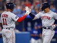 Masataka Yoshida, right, of the Red Sox celebrates with teammate Rafael Devers after hitting a solo home run in the sixth inning against the Blue Jays at Rogers Centre in Toronto, Friday, June 30, 2023.