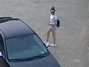A surveillance camera image showing a female suspect approaching a black Ford Focus in a car theft incident on Walker Road in Windsor on June 29, 2023.